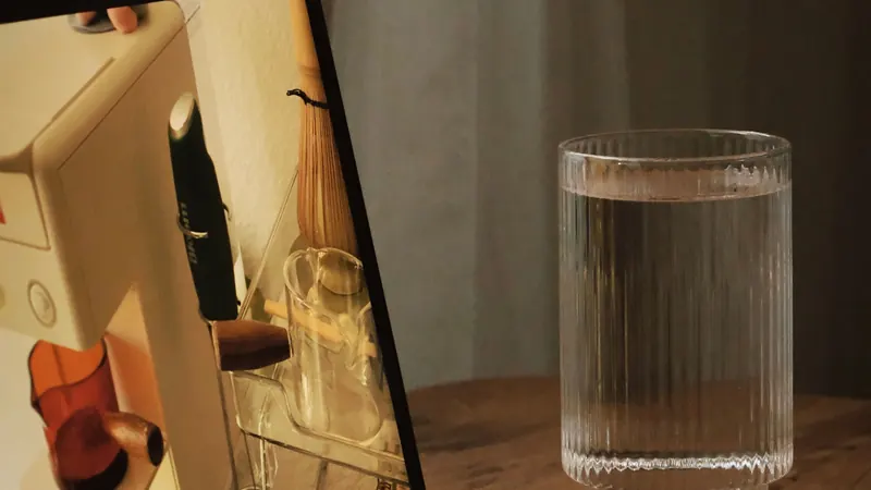 A glass of water beside a laptop on a desk