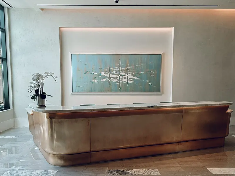 A hotel lobby with a reception desk and artwork